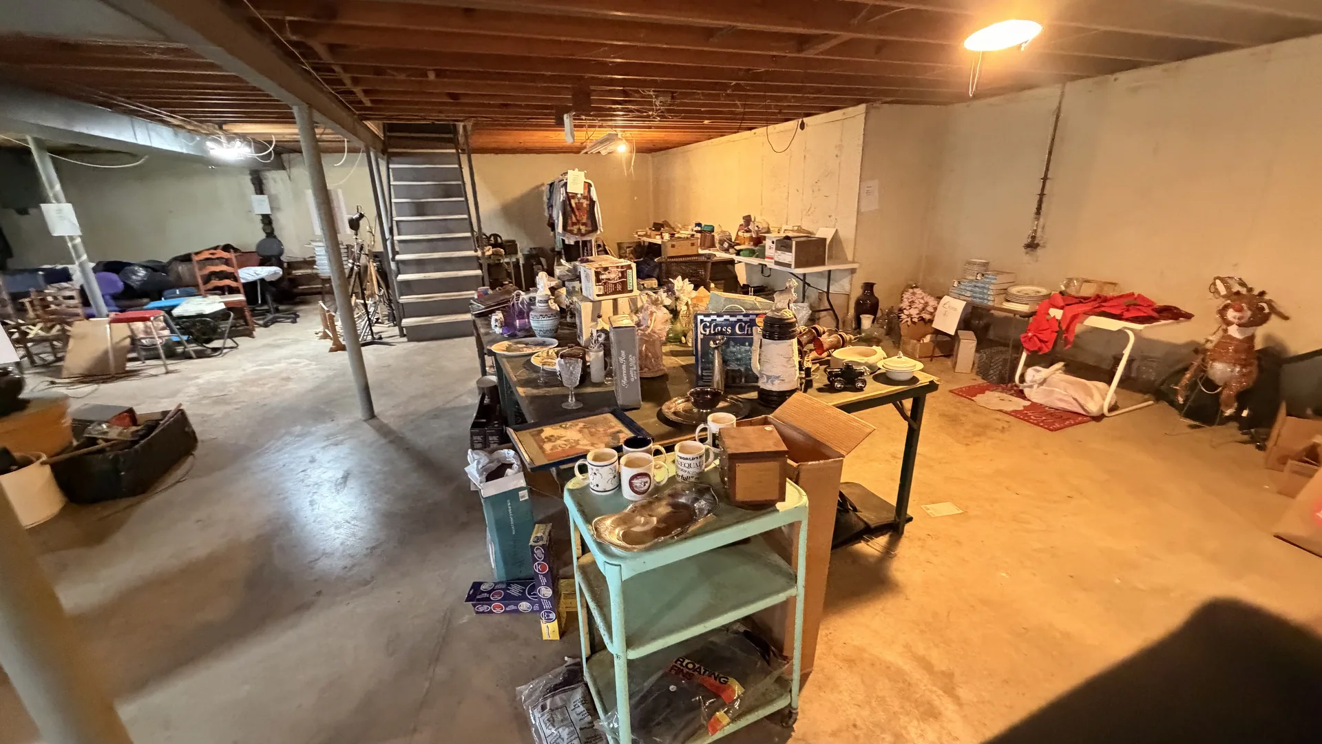 Unfinished basement wide view green metal cart mugs at an estate sale O'Fallon